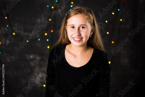 Portrait of cheerful teenage girl on festive background