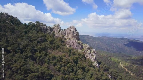 pull back drone shot in slow motion from big rock mass, cloudy sky and mountains in the background, sunny weather, in Karagol Nature Park of Izmir, Turkey photo