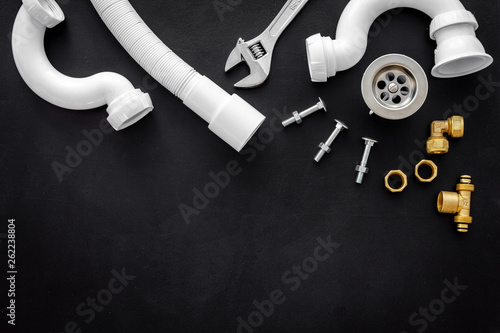 Professional instruments for plumber on black background top view space for text