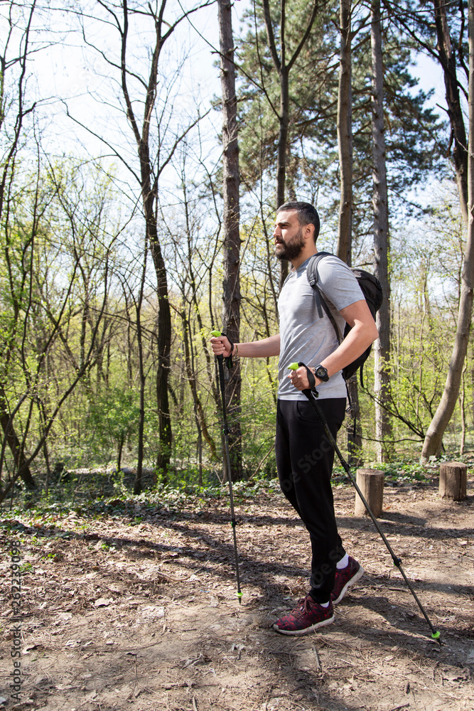 Man walking through a forest wearing a backpack.