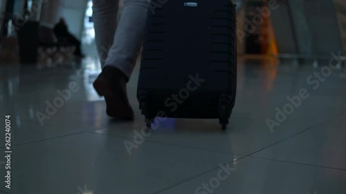 Close up shot of man legs with the baggage walking to the airport terminal.