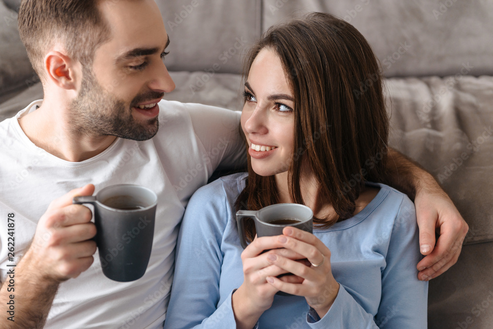 Beautiful young couple sitting at the couch Beautiful young couple sitting at the couch