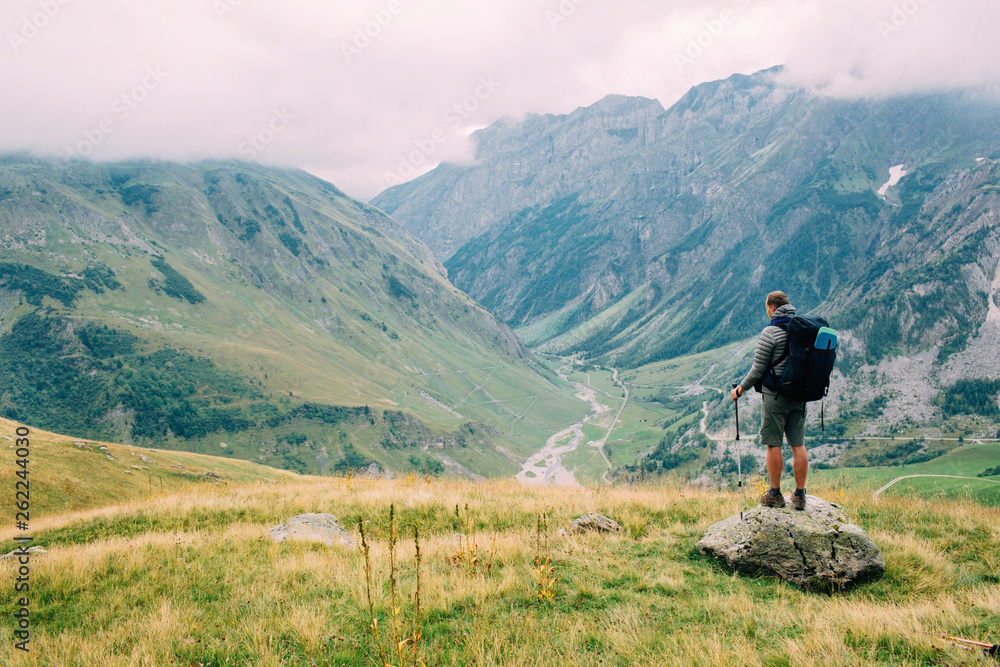 man with a backpack, looking on valley. Hiking around Mont Blanc, Alps Nature,France. Europe