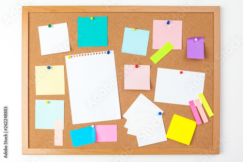 Cork board with several colorful blank notes with pins