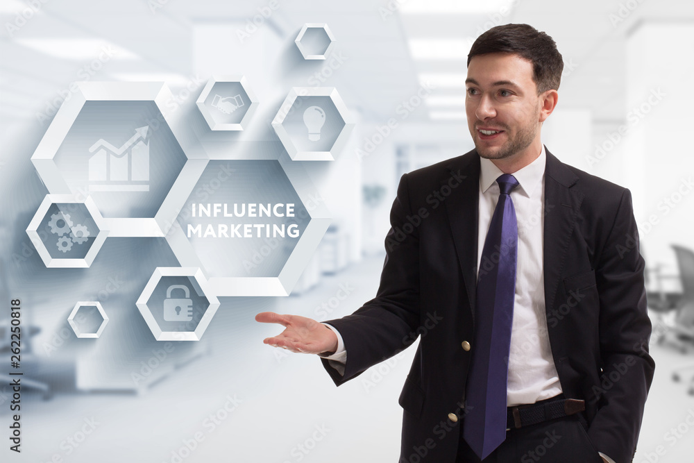 The concept of business, technology, the Internet and the network. A young entrepreneur working on a virtual screen of the future and sees the inscription: Influence marketing The concept of business, technology, the Internet and the network. A young entrepreneur working on a virtual screen of the future and sees the inscription: Influence marketing