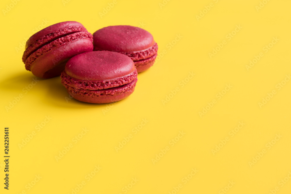 pink macaroons on yellow background. sweet pink cake pink macaroons on yellow background. sweet pink cake