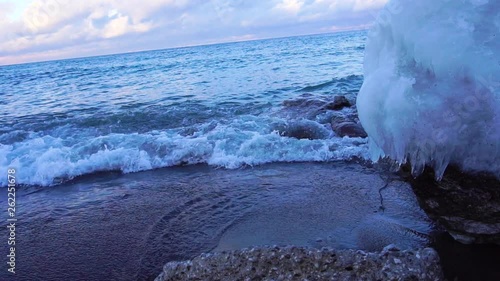 Slowmo waves on an icy beach at sunset in Canada. photo