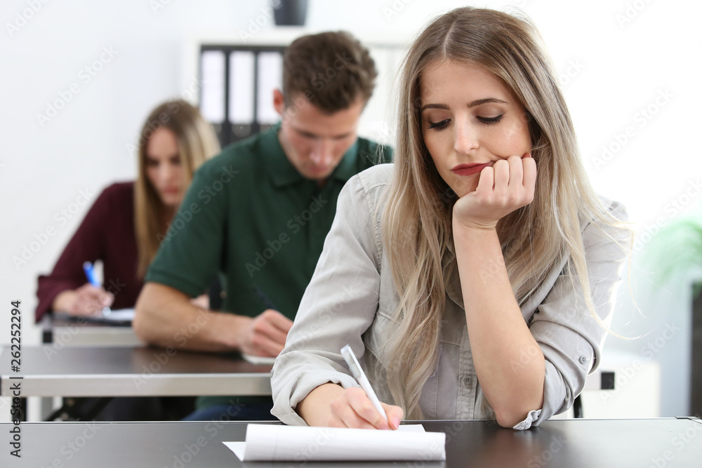 Frau schaut gelangweilt während sie einen Test absolviert Frau schaut gelangweilt während sie einen Test absolviert
