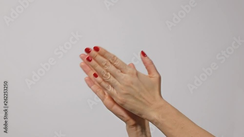 Woman doing claps her hands on a gray background photo