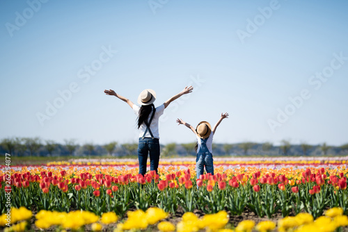 花畑で両手を上げる母と子 photo
