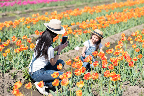 花畑で写真を撮る母と娘