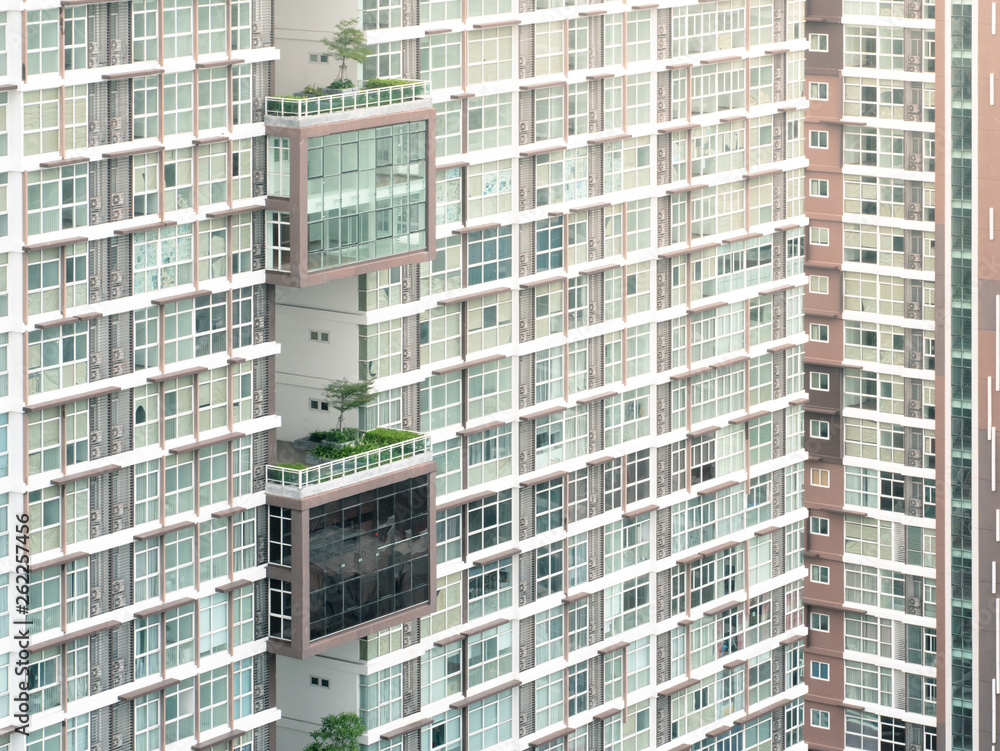 Close - up of a modern high condominium and tree at day time