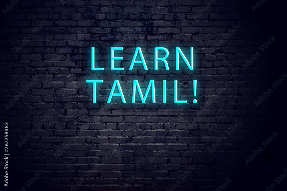 Brick wall and neon sign with inscription. Concept of learning tamil