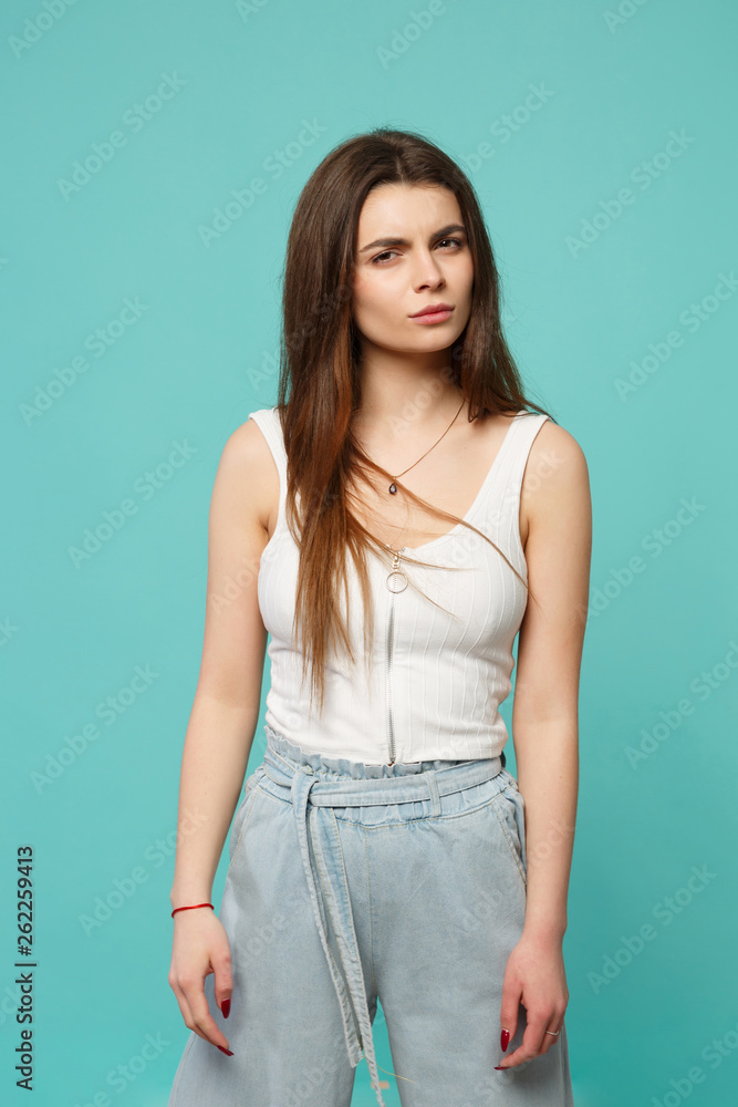 Portrait of perplexed bewildered young woman in light casual clothes looking camera isolated on blue turquoise background in studio. People sincere emotions, lifestyle concept. Mock up copy space. Portrait of perplexed bewildered young woman in light casual clothes looking camera isolated on blue turquoise background in studio. People sincere emotions, lifestyle concept. Mock up copy space.