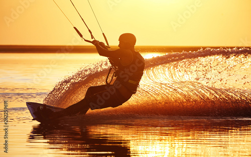 Kitesurfer at sunset with water splashes