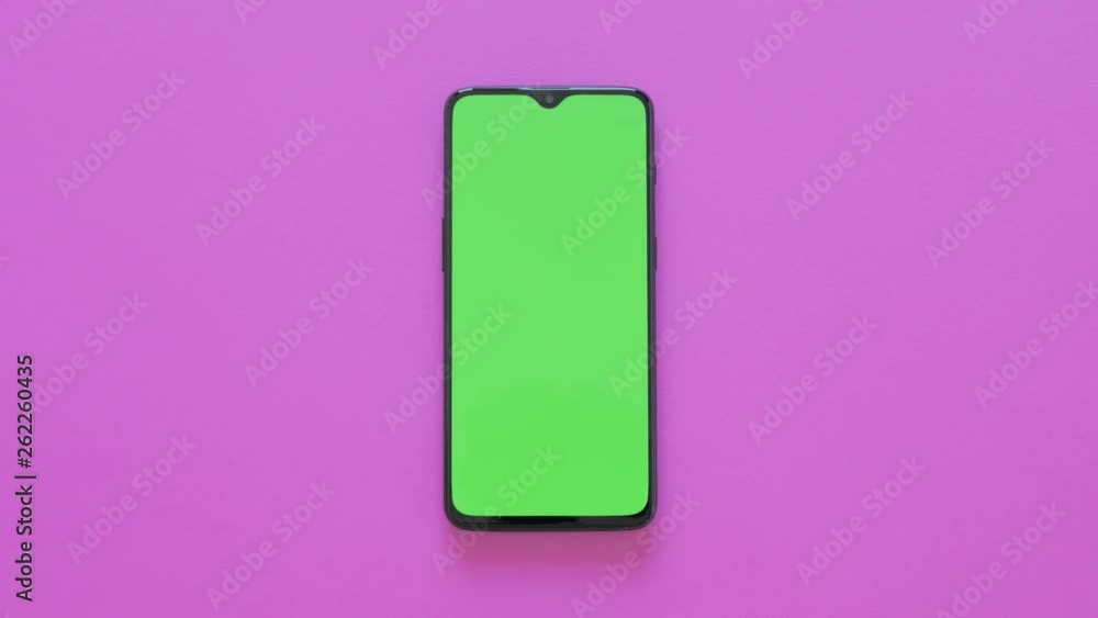 Green Screen - A modern smartphone lies on pink background Green Screen - A modern smartphone lies on pink background