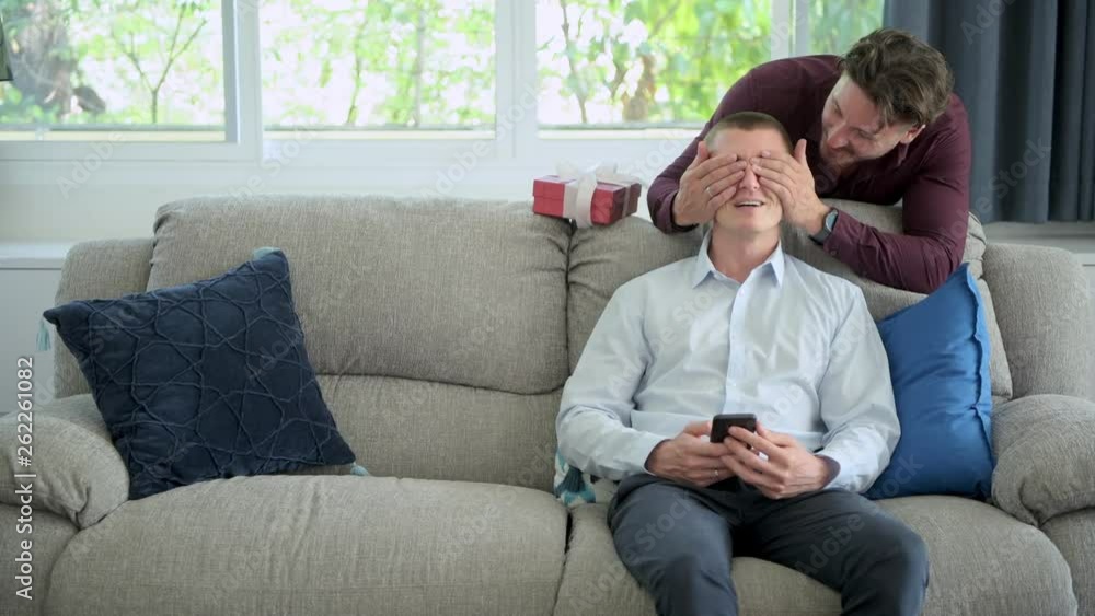 Young gay man give his boyfriend a surprise present. Caucasian male. Close eye and surprise. Friendship, homosexual, pride relationship concept. Young gay man give his boyfriend a surprise present. Caucasian male. Close eye and surprise. Friendship, homosexual, pride relationship concept.