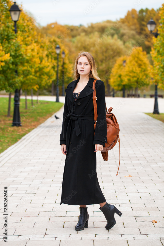 Fototapeta premium Portrait of a young beautiful woman in black coat