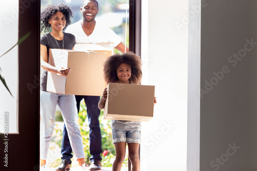 Happy African American family with daughter entering in new house