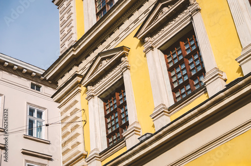 windows of the old European house are yellow with a bas-relief over the frame and columns.
