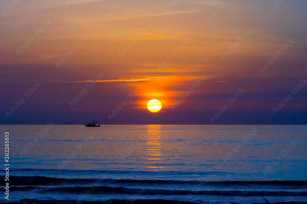 Colorful Seascape with Silhouette of Fishing Boat on the Ocean at Sunrise in Cocoa Beach, Florida