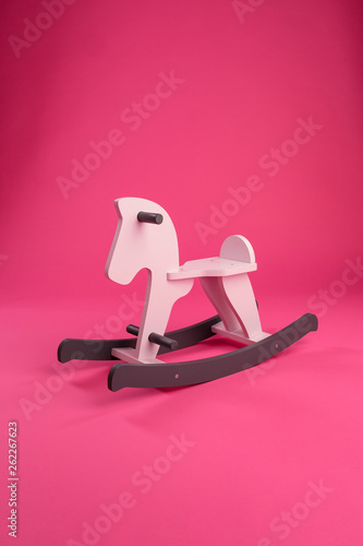Wooden children's rocking horse on a colored background