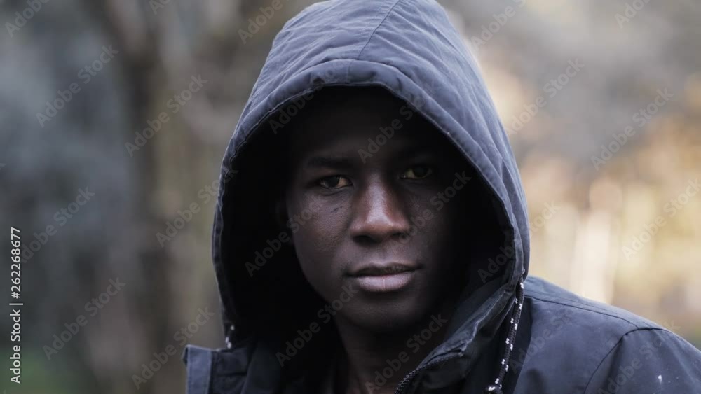 Confident serious hooded black african man staring at camera in the park Confident serious hooded black african man staring at camera in the park
