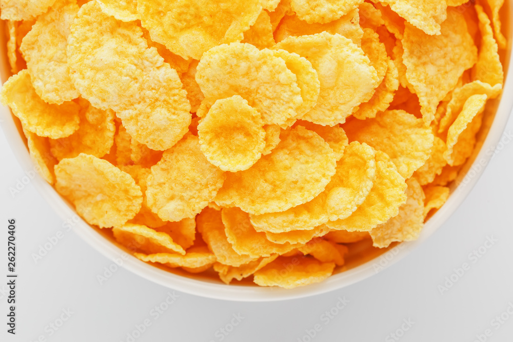 White cup with golden corn flakes isolated on white background. View from above. Delicious and healthy breakfast White cup with golden corn flakes isolated on white background. View from above. Delicious and healthy breakfast