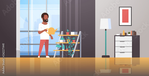 man watering potted plants on rack african american guy holding sprinkling can doing housework concept modern living room interior male cartoon character full length horizontal