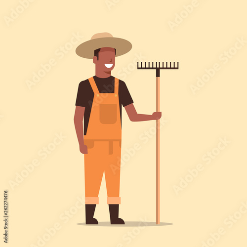 gardener holding rake african american country man working in garden gardening eco farming concept full length