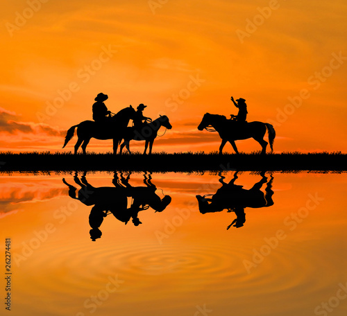 silhouette Cowboy riding a horse on sunrise © rathchapon