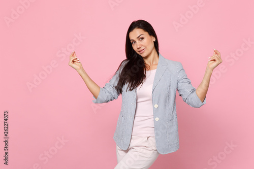 Portrait of smiling beautiful young woman in striped jacket rubbing, snapping fingers isolated on pink pastel wall background in studio Fototapete