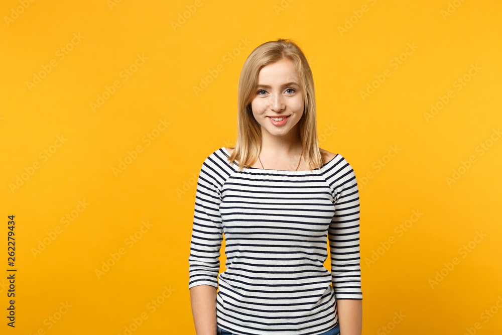 Beautiful smiling young blonde woman in striped clothes looking camera isolated on bright yellow orange wall background, studio portrait. People sincere emotions lifestyle concept. Mock up copy space. Beautiful smiling young blonde woman in striped clothes looking camera isolated on bright yellow orange wall background, studio portrait. People sincere emotions lifestyle concept. Mock up copy space.