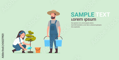 couple farmers planting young tree man holding water buckets woman digging soil working in garden agricultural gardening concept flat full length copy space horizontal
