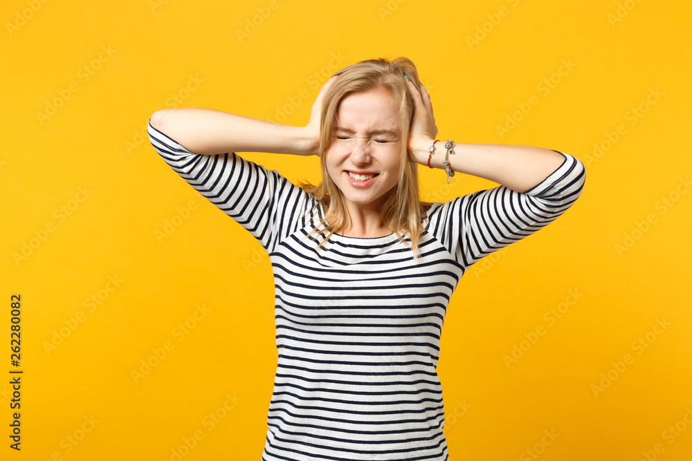 Smiling happy young woman in striped clothes keeping eyes closed, putting hands on head isolated on yellow orange background in studio. People sincere emotions, lifestyle concept. Mock up copy space. Smiling happy young woman in striped clothes keeping eyes closed, putting hands on head isolated on yellow orange background in studio. People sincere emotions, lifestyle concept. Mock up copy space.