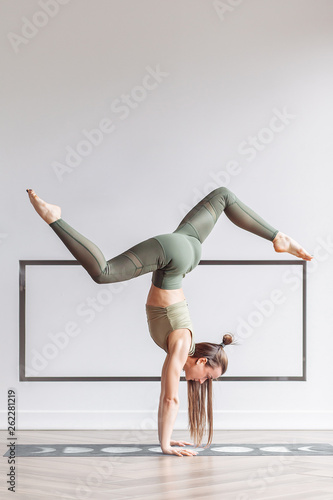 Photography Beautiful young fitness model doing a difficult handstand in the gym