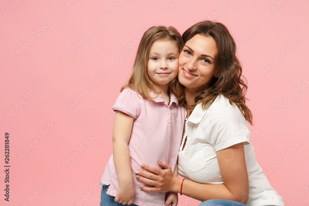 Woman in light clothes have fun with cute child baby girl. Mother, little kid daughter isolated on pastel pink wall background, studio portrait. Mother's Day, love family, parenthood childhood concept