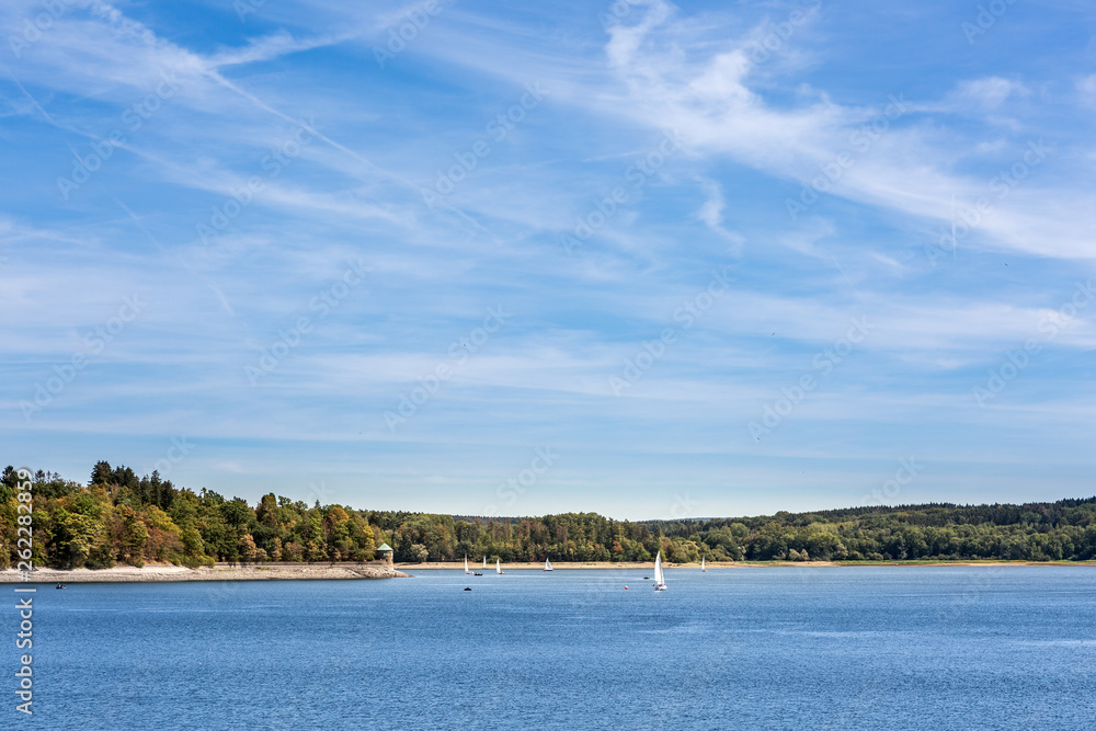 Ein sonniger Tag am See voller Wassersportler und Segelboote