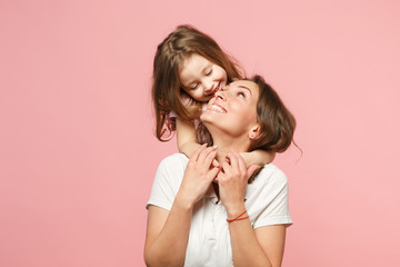 Woman in light clothes have fun with cute child baby girl. Mother, little kid daughter isolated on pastel pink wall background, studio portrait. Mother's Day, love family, parenthood childhood concept