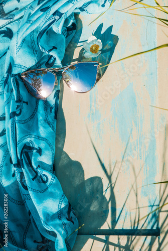 Blue sunglasses mirror sunglasses and summer scarf on a wooden background. Fashion concept, retro photo