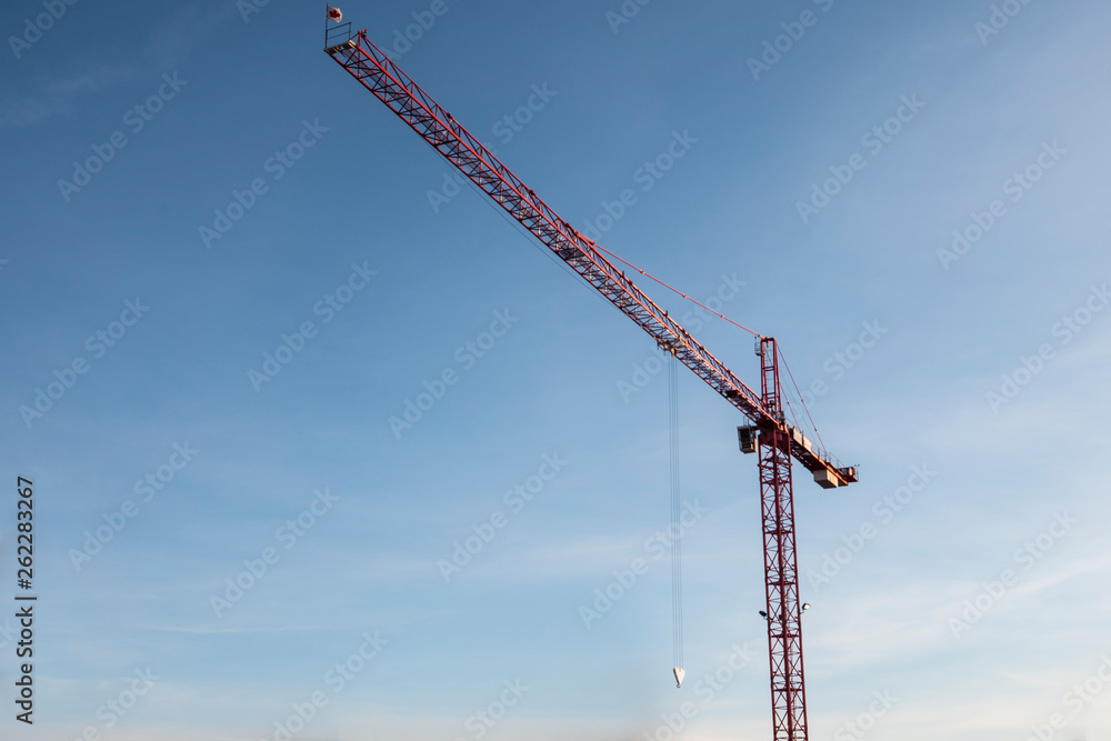 A tall construction crane lifting large materials in Calgary Alberta Canada A tall construction crane lifting large materials in Calgary Alberta Canada