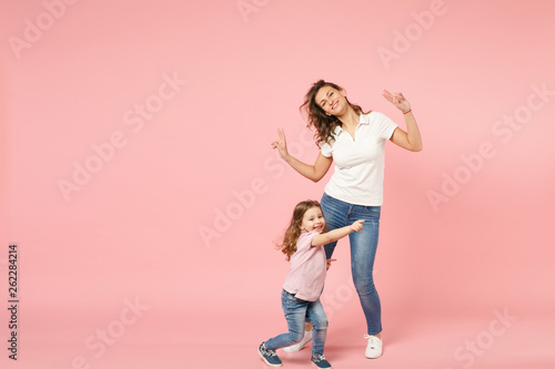 Woman in light clothes have fun with cute child baby girl. Mother, little kid daughter isolated on pastel pink wall background, studio portrait. Mother's Day, love family, parenthood childhood concept