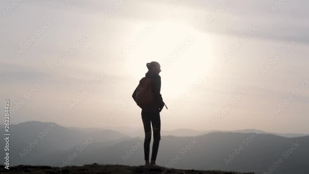 silhouette of Young woman jumping and enjoying life on mountain on sunset sky and mountains background silhouette of Young woman jumping and enjoying life on mountain on sunset sky and mountains background