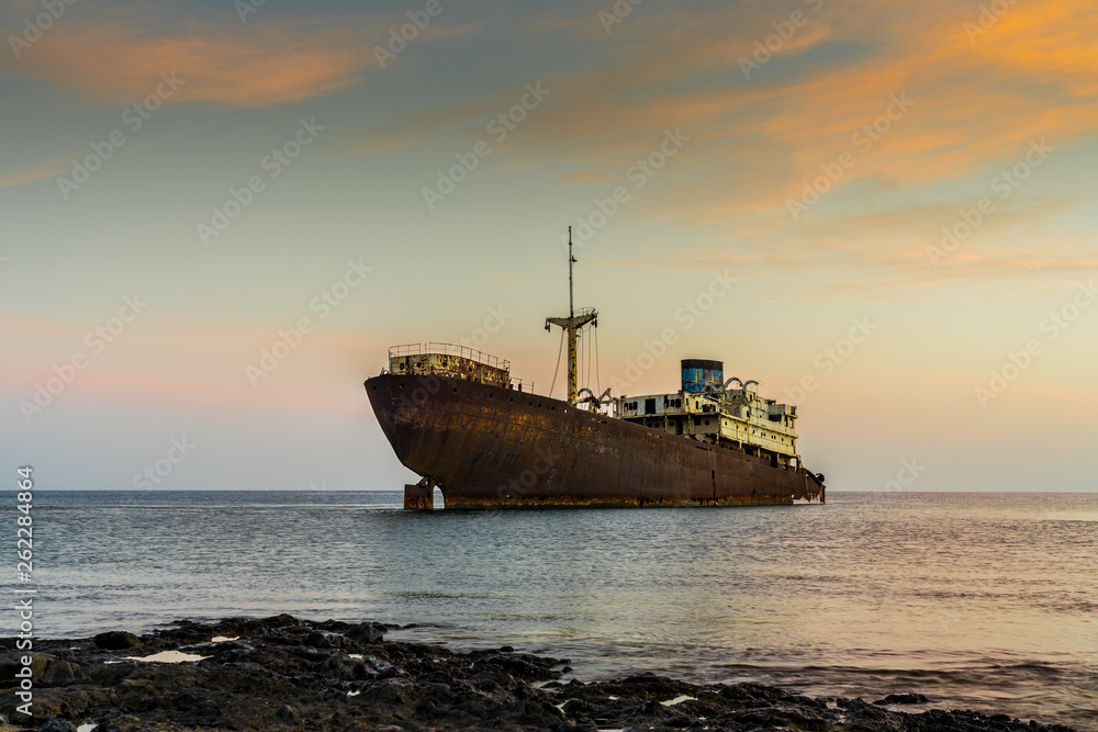 Spain, Lanzarote, Temple hall boat wreck stranded at coast of the island in magic afterglow light