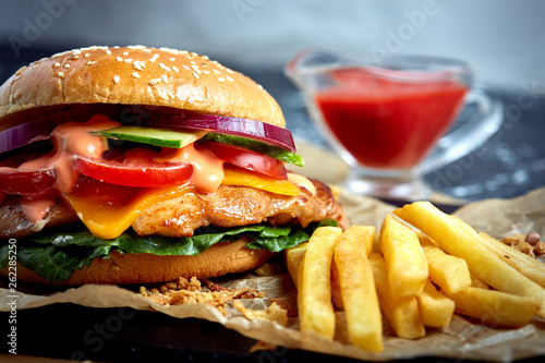 Delicious burgers with beef, tomato, cheese and french fries with tomato sauce