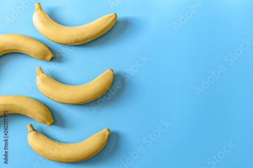 Five bananas on a blue pastel background. Minimal concept.