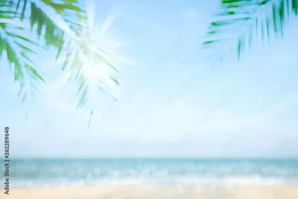Abstract soft blur nature tropical beach with green coconut palm leaf and light wave bokeh background concept for blurry sky summer landscape water and sand, holiday ocean travel, relax vacation day