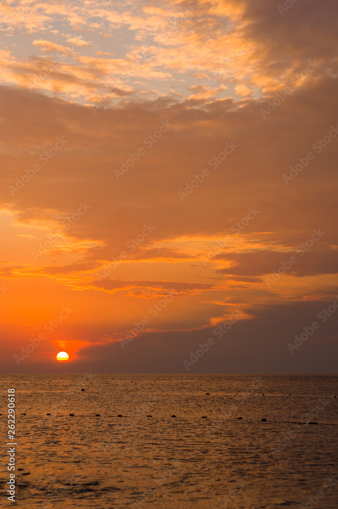 Amazing sea sunset on the pebble beach, the sun, waves, clouds