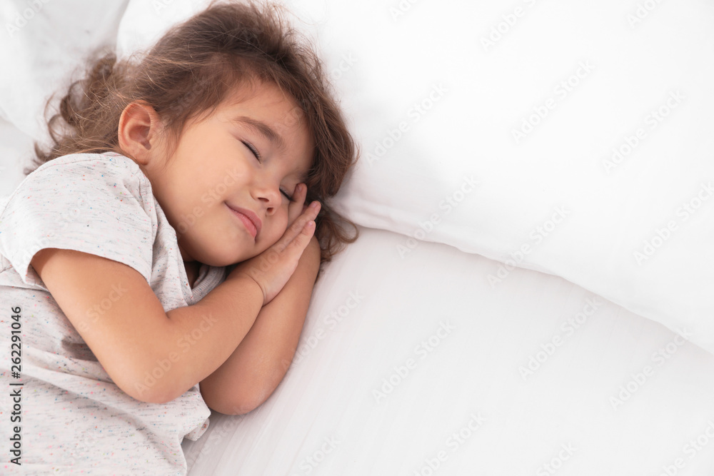 Cute little girl sleeping on bed. Space for text Cute little girl sleeping on bed. Space for text