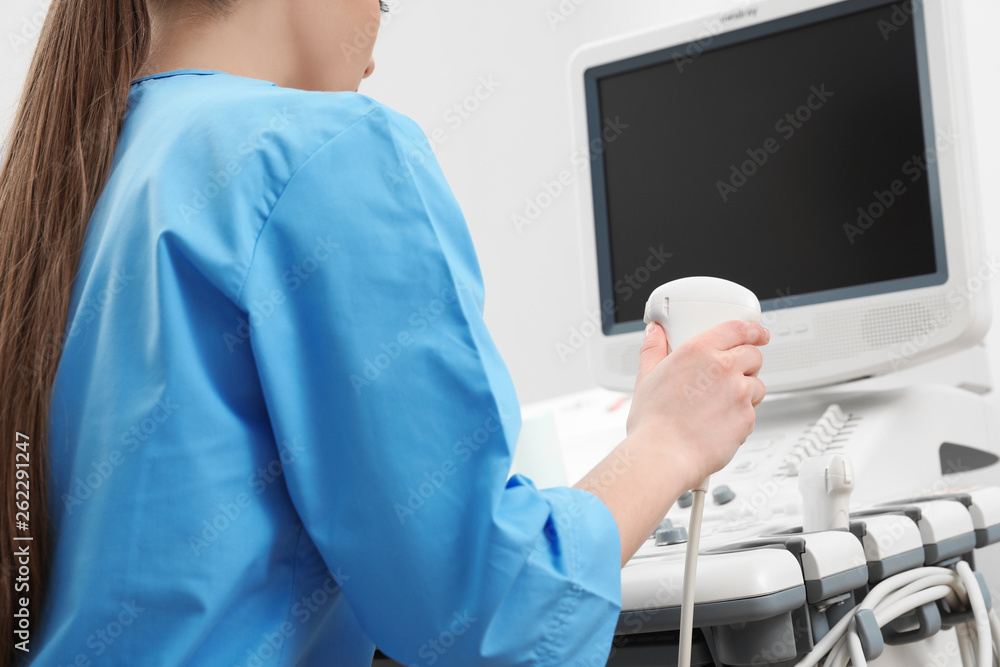 Sonographer operating modern ultrasound machine in clinic, closeup Sonographer operating modern ultrasound machine in clinic, closeup